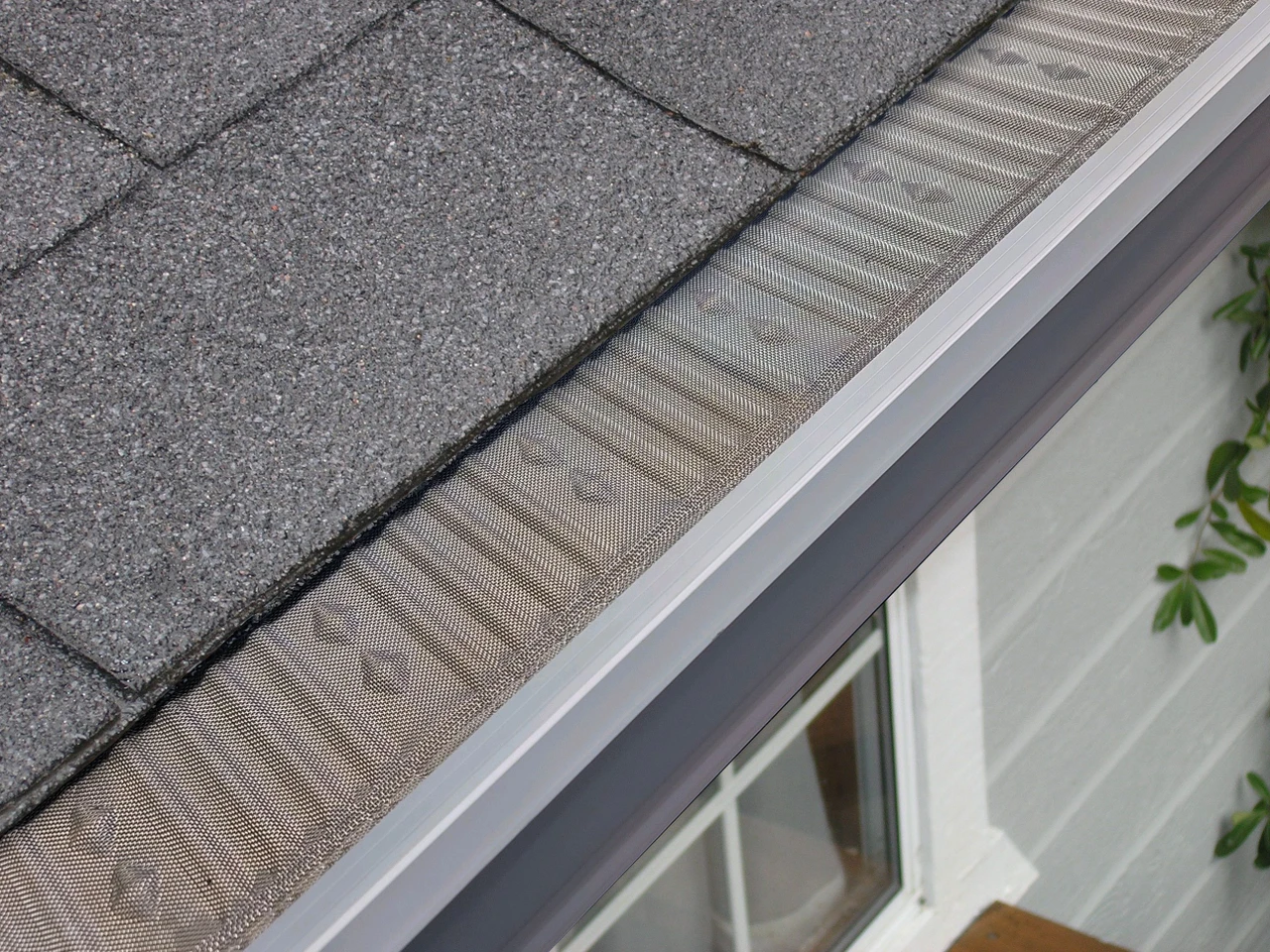 Close-up of Leaf Stopper micro-mesh fitted neatly along an asphalt shingle roof